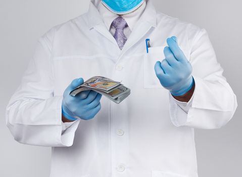doctor in a white coat and tie, wearing blue sterile gloves, doctor holds a pack of paper money, anti-corruption concept, bribe and payment for the work done