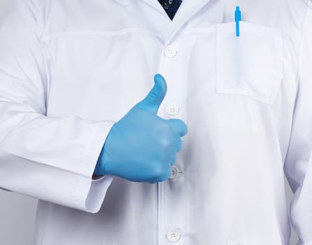 doctor in a white coat and tie shows with his hand a gesture like, wearing blue latex medical gloves, close up