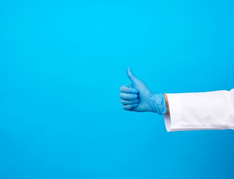 doctor in a white coat shows with his hand a gesture like, wearing blue latex medical gloves, close upm copy space