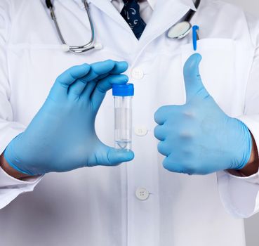 doctor in a white coat and blue sterile latex gloves holds a plastic jar for stool analysis, white background