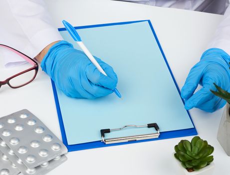 woman doctor in a white coat, sterile medical gloves writes a prescription on a form, therapist sits, workplace