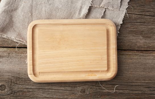 light beige rectangular empty cutting kitchen board on a wooden background from old boards, top view