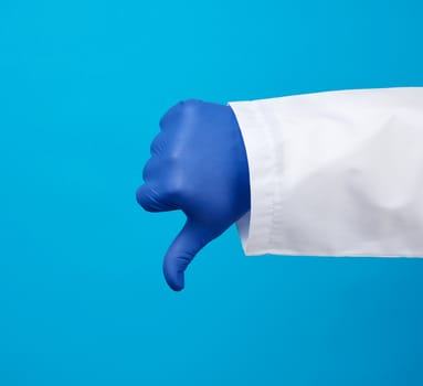 doctor in a white coat with buttons shows a gesture of dislike with his hand, wearing blue medical glove, emotion of negativity