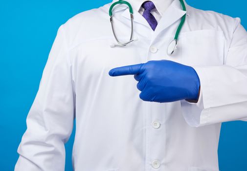 medic man in white coat with buttons, on hands wearing blue sterile gloves, showing hand gesture indicating the subject, white background