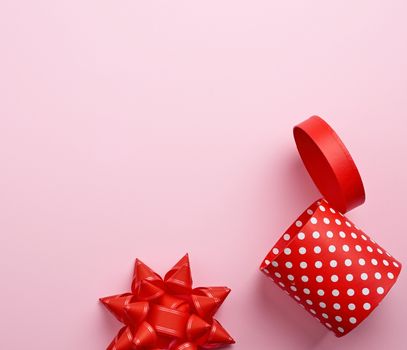 empty round red cardboard box in white polka dots on a pink background, holiday backdrop