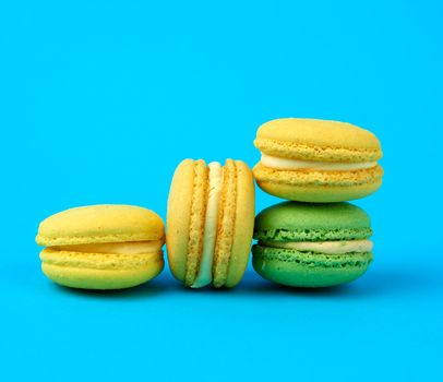 multi-colored round baked macarons cakes on a light blue background,  close up