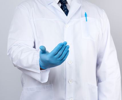doctor in a white coat with buttons and blue latex gloves holds out his hand forward, concept of invitation, handshake, white background