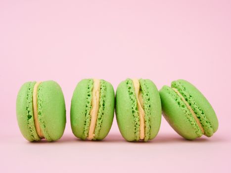 green round baked macaroon macarons on a pink background, delicious popular french dessert