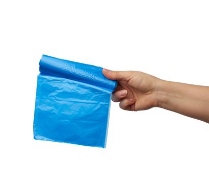 female hand holds a bundle of blue plastic bags for garbage, part of the body with the subject isolated on a white background