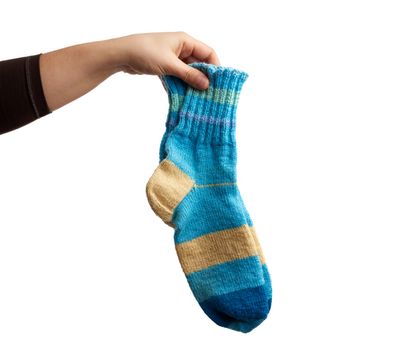 female hand holds a pair of knitted woolen socks, warm clothes, item is isolated on a white background 