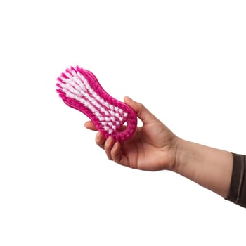 hand holds a pink plastic brush for cleaning housework, white background, close up