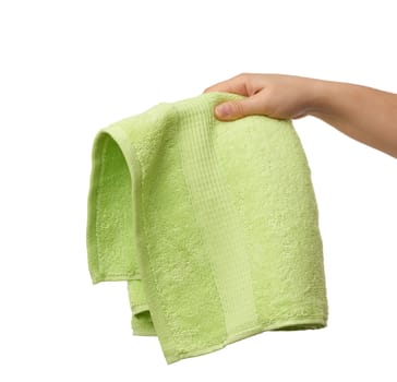 female hand holds a green terry towel on a white isolated background, close up