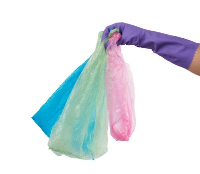 hand holds an empty green plastic bag on a white background, concept of rejection of plastic and the transition to eco-packaging