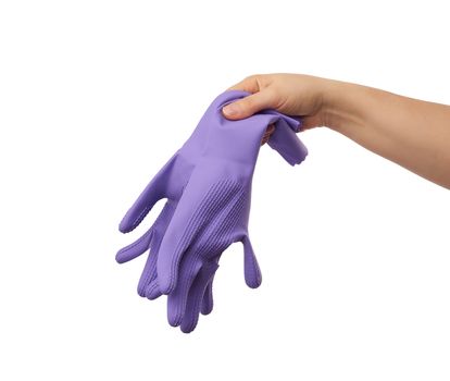 female hand holds a pair of purple rubber gloves for cleaning the house, protection against chemicals