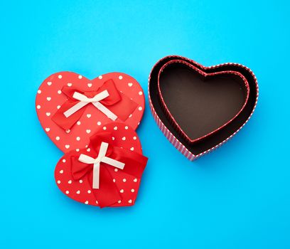 open empty red cardboard box in the form of a heart on a light blue background, top view, element for a designer