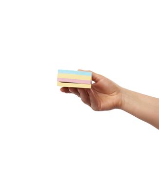 female hand and many empty paper multi-colored stickers on a white background, close up