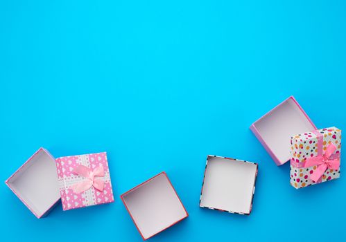 open brown square cardboard empty box, item lies on a blue background, top view, copy space