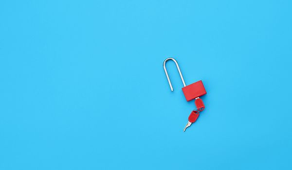 metal open padlock with keys on a blue background, copy space