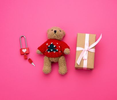 brown gift box and little brown teddy bear on a pink background, top view
