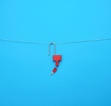 metal open padlock with keys on a blue background, copy space