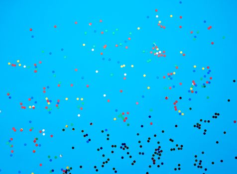 shiny multicolored round confetti scattered on a blue background, festive backdrop for birthday, valentines day. Festive decoration element. Flat design 
