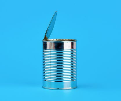 open hard iron can for food preservation on a blue background, copy space
