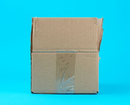 open brown cardboard box on a blue background. Transportation, shipping. Packaging container