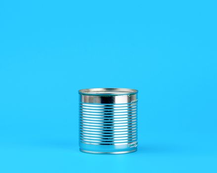 closed hard iron can for food preservation on a blue background, copy space