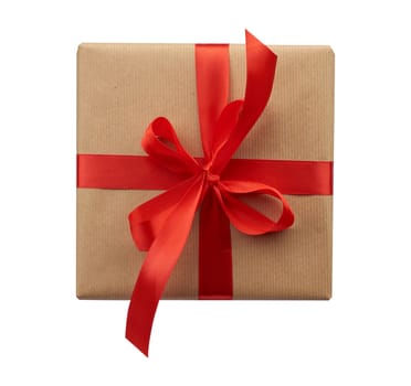 square box wrapped in brown kraft paper and tied with a silk red ribbon, top view, gift isolated on a white background