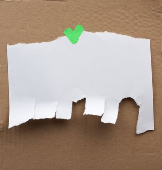blank paper ad with torn edges attached with a green velcro on a brown cardboard surface, backdrop for sales and messages, copy space