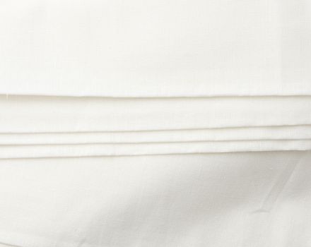 white cotton fabric folded, full frame, textile for sewing clothes and bedding, close up