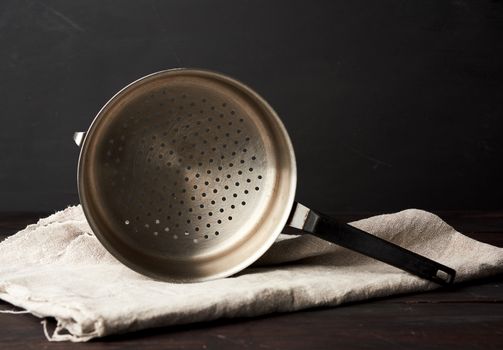 iron vintage colander on a wooden table, close up