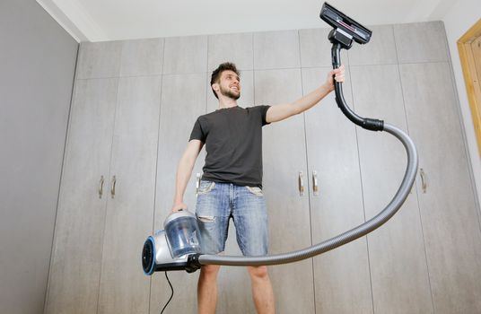 House cleaning. Man with a vacuum cleaner