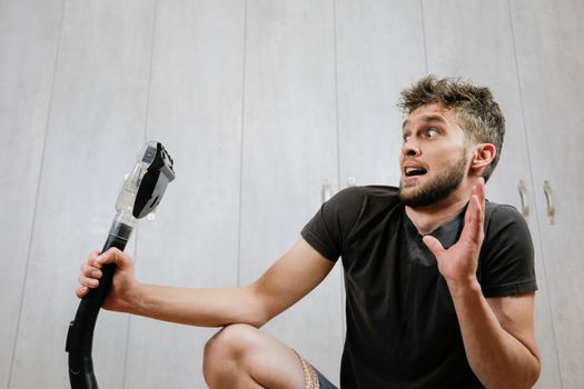 House cleaning. Man with a vacuum cleaner