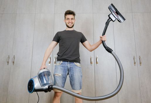 House cleaning. Man with a vacuum cleaner