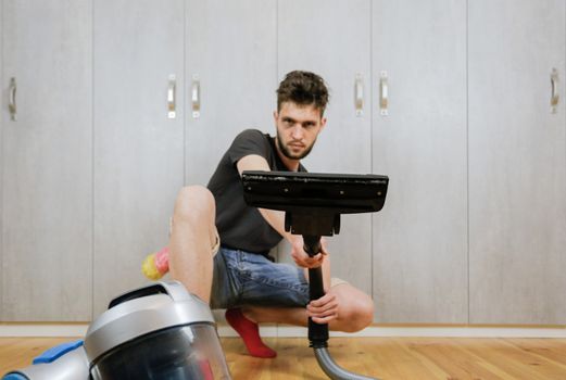 House cleaning. Man with a vacuum cleaner