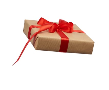 square box wrapped in brown kraft paper and tied with a silk red ribbon, side view, gift isolated on a white background