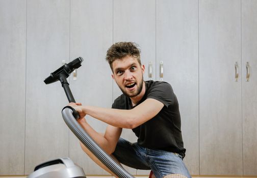 House cleaning. Man with a vacuum cleaner