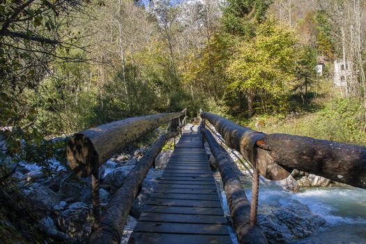 Bridge over the mountain stream in the middle of dolomites mountains in Italy