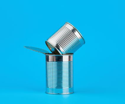 open hard iron can for food preservation on a blue background, copy space