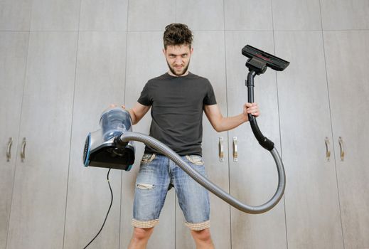 House cleaning. Man with a vacuum cleaner