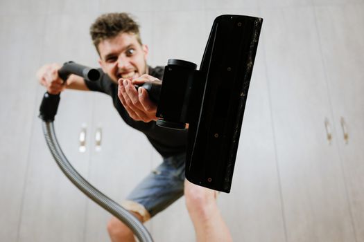 House cleaning. Man with a vacuum cleaner