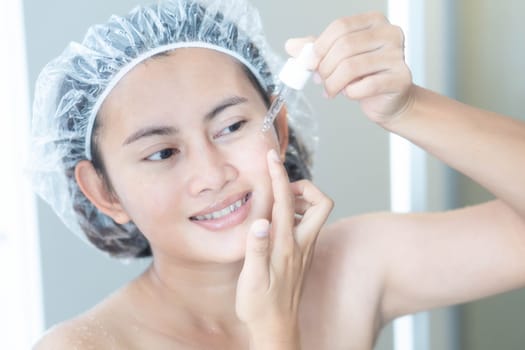 Woman hand applying cream on her face with happy feeling, health care and beauty concept