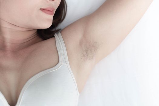 Women problem black armpit lying on white bed background for skin care and beauty concept, selective focus