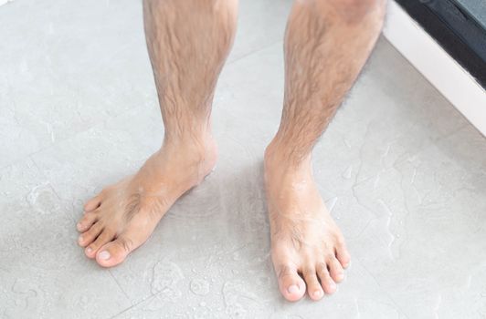 Close up man legs with taking a shower in the bathroom, health care and beauty