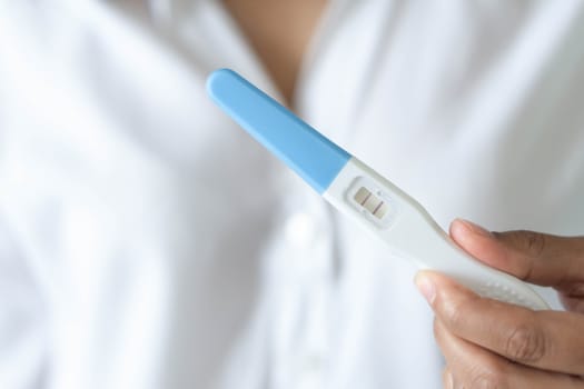 Closeup woman hand holding pregnancy test with happy moment, health care concept, selective focus