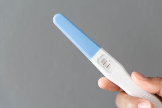 Closeup woman hand holding pregnancy test with happy moment, health care concept, selective focus