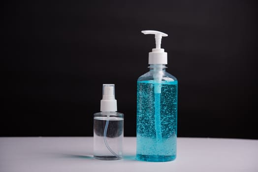 Plastic dispenser sanitizer alcohol gel pump and spray bottle for washing hand hygiene prevention of coronavirus virus studio shot on black background