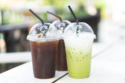 Close up glass of ice matcha green tea and ice coffee on wood table, selective focus