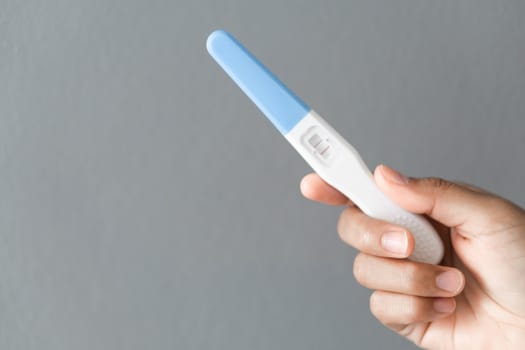 Closeup woman hand holding pregnancy test with happy moment, health care concept, selective focus